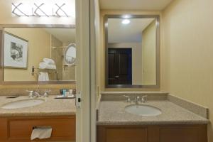a bathroom with two sinks and a large mirror at Crowne Plaza Albuquerque by IHG in Albuquerque