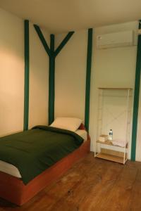 1 dormitorio con 1 cama con una cruz en la pared en Cabana Surf and Stay, en Biha