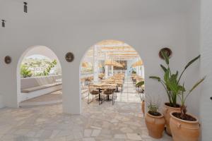 une salle à manger avec des tables, des chaises et des plantes en pot dans l'établissement Belmare Hotel-Adults Οnly, à Lardos