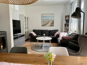 a living room with a couch and a table at Fehmarn Ahoi FamKreil bis 6,5 Pers in Fehmarn