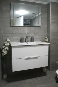a bathroom with a white sink and a mirror at Stylish & relaxing 70 sq. m. flat with balcony in Athens