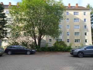 tres autos estacionados en un estacionamiento frente a un edificio en Oederan One Room Apartment 33m2 Mindestens 1 Monat Reservierung, en Oederan
