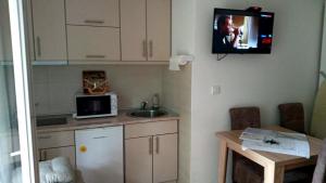 a small kitchen with a sink and a microwave at PremiumPlus Apartman in Vrnjačka Banja
