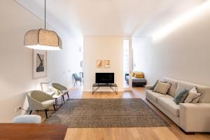 a living room with a couch and a tv at 4-Suites Batalha Residence & SIZE Flats Batalha in Porto