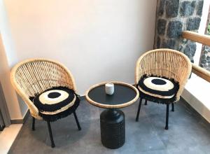 two wicker chairs with a table at Aidani Luxurious Rooms in Vóthon