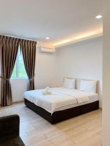 een slaapkamer met een groot bed en een raam bij Vvip Hotel in Hutan Melintang