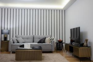 ein Wohnzimmer mit einem Sofa und einem TV in der Unterkunft Bristol Apartment in the Centre of Zagreb in Zagreb