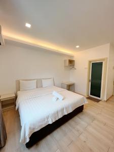 a bedroom with a large bed with white sheets at Vvip Hotel in Hutan Melintang