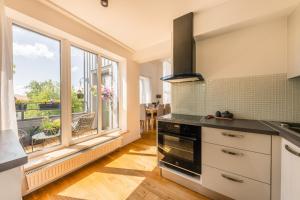 a kitchen with a stove top oven next to a window at Luxury Three-Bedrooms Apartment in Liepāja