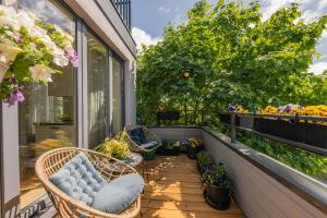 a balcony with wicker chairs and plants on it at Luxury Three-Bedrooms Apartment in Liepāja