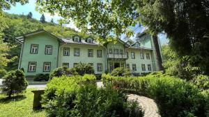 ein großes, grünes Gebäude inmitten eines Gartens in der Unterkunft Maria in Rymanów-Zdrój