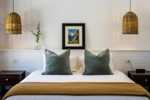 1 dormitorio con 1 cama con almohadas verdes en MAIN STREET RETREAT - King BRs, Comp Minibar, Breakfast Prov, Fireplaces, en McLaren Flat