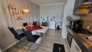 a kitchen with a white table and black chairs at Ferienwohnung Bergwichtel Hahnenklee "super Aussicht" in Hahnenklee-Bockswiese +19 photos