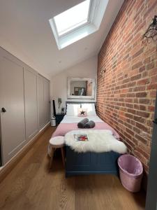 a bedroom with a bed and a brick wall at New Converted Barn in Hereford