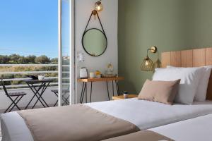 a bedroom with a bed with a mirror and a balcony at Charm Hotel, Hersonissos in Hersonissos