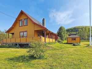 6 person holiday home in Kviby في Kviby: منزل خشبي كبير في حقل عشبي