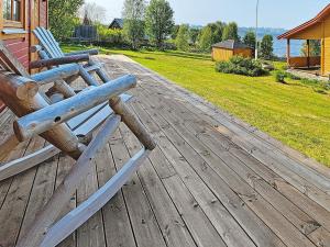 6 person holiday home in Kviby في Kviby: السطح خشبي مع كرسيين خشبيين على المنزل