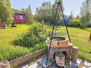 una hoguera en un jardín con una casa al fondo en 6 person holiday home in Kviby, en Kviby