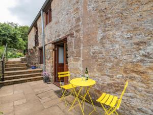 a yellow table and chairs in front of a stone building at The Old Granary in Beaminster