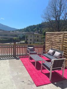 2 Stühle und ein Tisch auf einem rosa Teppich in der Unterkunft 7rooms Losone in Losone