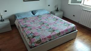 a bedroom with a bed with a floral quilt on it at PESCARA HOME anto in Pescara