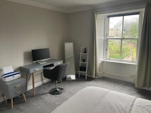 a bedroom with a desk with a computer and a window at Lovely 2 bedroom condo in Burntisland, Fife in Burntisland