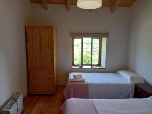 a bedroom with two beds and a window at Ca Bastiana in La Piñera