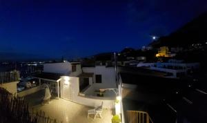 a white building with two chairs on the roof at night at Coralinetiny in Castellammare di Stabia