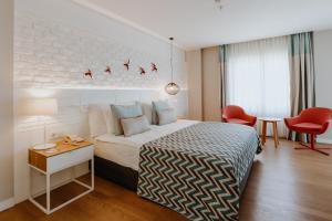Habitación de hotel con cama, mesa y sillas en Akra Kemer - Ultra All Inclusive, en Kemer
