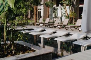 a row of white lounge chairs next to a pool at Akra Kemer - Ultra All Inclusive in Kemer