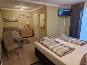 1 dormitorio con 1 cama, 1 silla y TV en Ferienwohnung Teltow 2, en Teltow