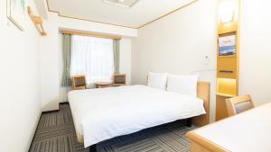 a hotel room with a white bed and a window at Toyoko Inn Hokkaido Sapporo Susukino Kosaten in Sapporo