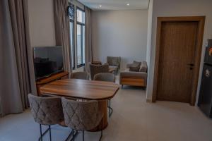 a living room with a table and chairs and a television at منتجع دلال الفندقي Dalal Hotel Resort in Dammam