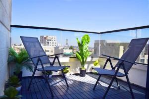 2 chaises assises sur un balcon avec des plantes dans l'établissement Luxury 120m2 in city center, Best location!, à Jérusalem