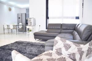 Il comprend un salon avec un canapé en cuir et une cuisine. dans l'établissement Luxury 120m2 in city center, Best location!, à Jérusalem