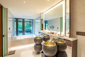 La salle de bains est pourvue de 3 lavabos et d'un grand miroir. dans l'établissement Diaoyutai Boutique Hotel Chengdu, à Chengdu
