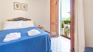 Un dormitorio con una cama azul con toallas. en Welcomely - Retiro Perpignan, en Alghero