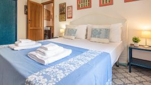 1 dormitorio con 1 cama grande y toallas. en Welcomely - Retiro Perpignan, en Alghero