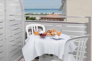 une table blanche avec une assiette de nourriture sur un balcon dans l'établissement Residence Nautic, à Rimini