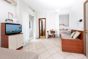 ein Wohnzimmer mit einem Bett und einem TV. in der Unterkunft Residence Nautic in Rimini