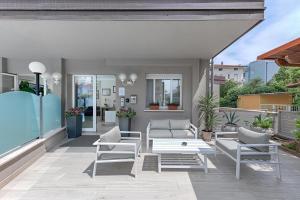 eine Terrasse mit Stühlen, einem Sofa und einem Tisch in der Unterkunft Residence Nautic in Rimini