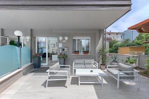 a patio with chairs and a couch and a table at Residence Nautic in Rimini