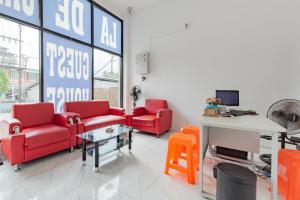 a waiting room with red chairs and a table at Urbanview Hotel La De Grizz Syariah Sampit by RedDoorz in Sampit