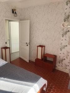 een slaapkamer met een bed, een deur en een muur bij Chambre Japonaise baieta in Moulinet