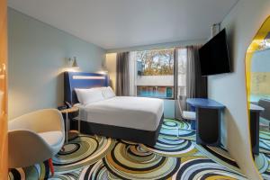 Adge Hotel and Residences في سيدني: غرفة فندق بسرير وتلفزيون