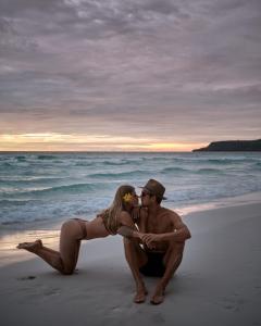 un hombre y una mujer sentados en la playa en Sweet Dreams Koh Rong, en Koh Rong