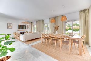 a dining room and living room with a table and chairs at VACATION MARBELLA I Villa Sirio, Golf-Front Villa, Private Pool, Privacy in Marbella