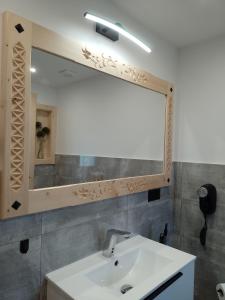 a bathroom with a sink and a large mirror at Domek Na Góralską Mode in Suche