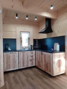 a kitchen with wooden cabinets and a black counter top at Domek Na Góralską Mode in Suche