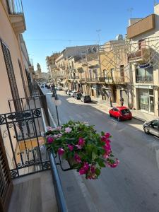 un balcón con un ramo de flores en una calle en Bon Bon Apartment, en Mazara del Vallo